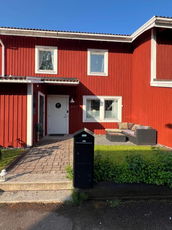 a red house with a trash can in front of it at Rymligt radhus in Borlänge