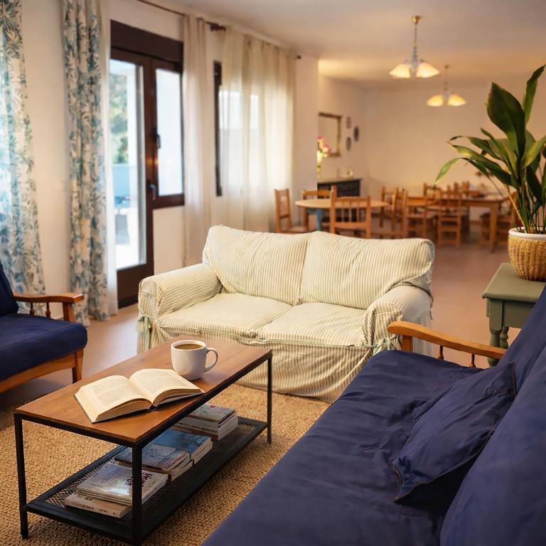 a living room with a couch and a table with a book at HOSTEL Villanueva in Villanueva de Alcorón