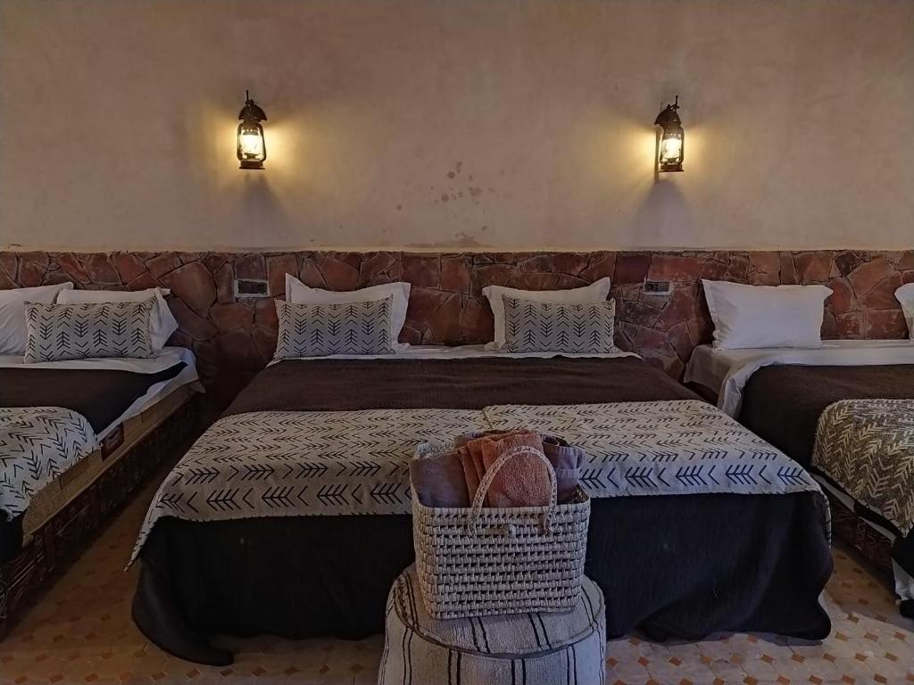 a hotel room with two beds and a basket at Camels House in Merzouga