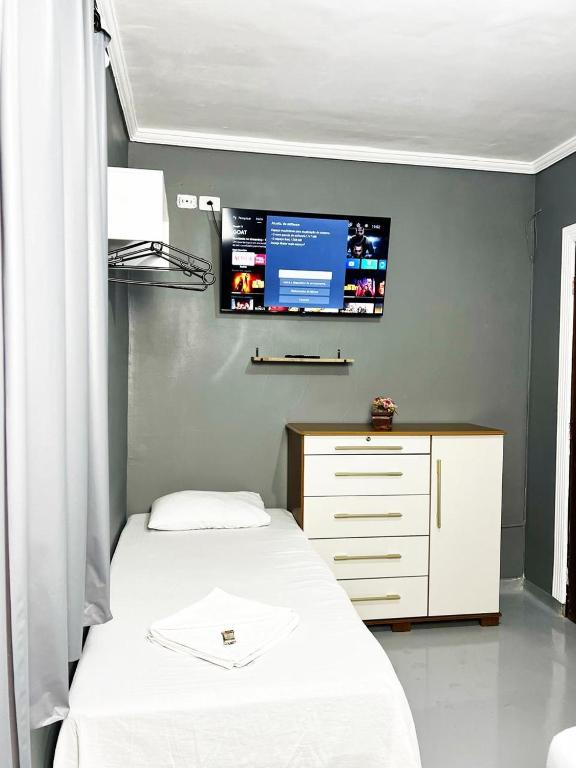 a bedroom with two beds and a tv on the wall at Hostel Anprado #1 Kit café incluso, Próx-Aeroporto de Guarulhos in Guarulhos