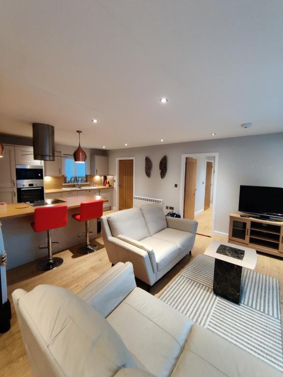 a living room with white furniture and a kitchen at Durham Norwood detached Bungalow in Trimdon Grange