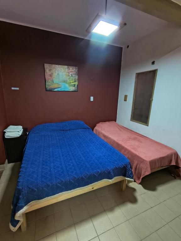a bedroom with a bed with a blue comforter at Departamento PB 1 Centro Pileta in Formosa