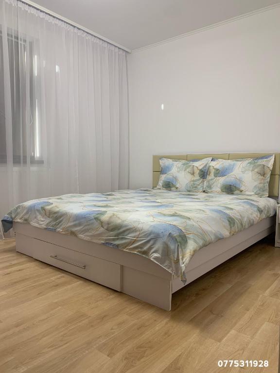 a bed in a white bedroom with a white wall at Apartament central in Râmnicu Vâlcea