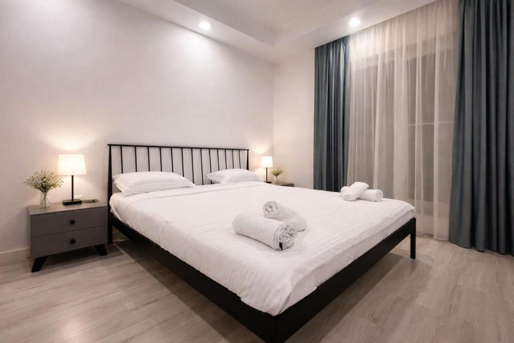 a bedroom with a large bed with towels on it at Nivora apartament #freeparking in Tunari