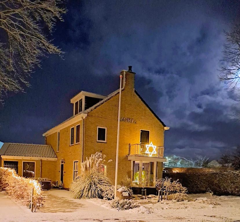 een gebouw met een balkon aan de zijkant bij B&B Moria in Surhuisterveen