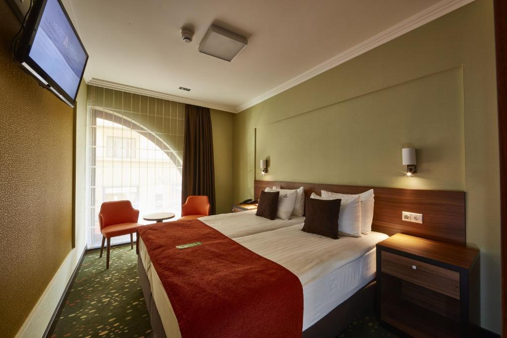 a hotel room with a large bed and a television at Budget Hotel Victoria in Budapest