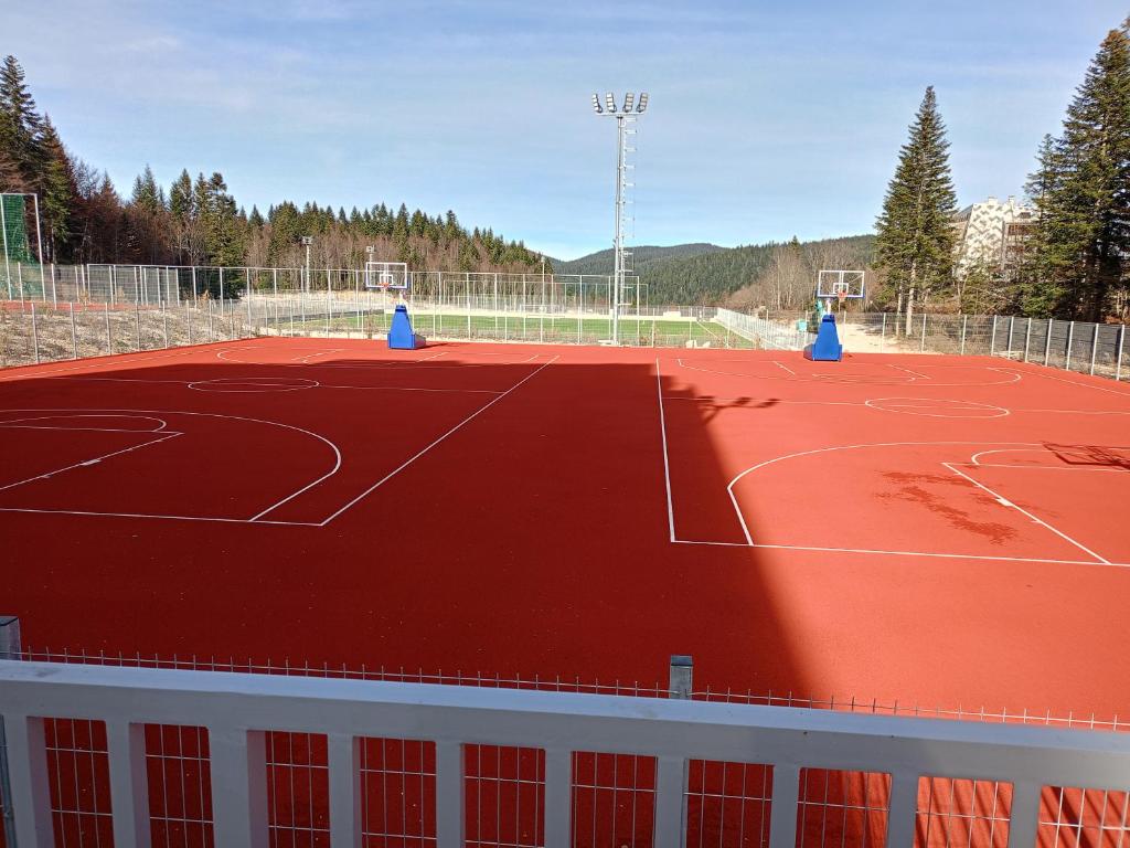 an orange basketball court with blue cones on it at A-Apartman in Bjelašnica
