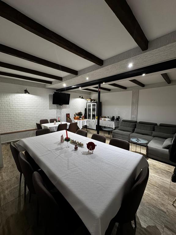a dining room with a white table and a couch at View Racha in Ambrolauri