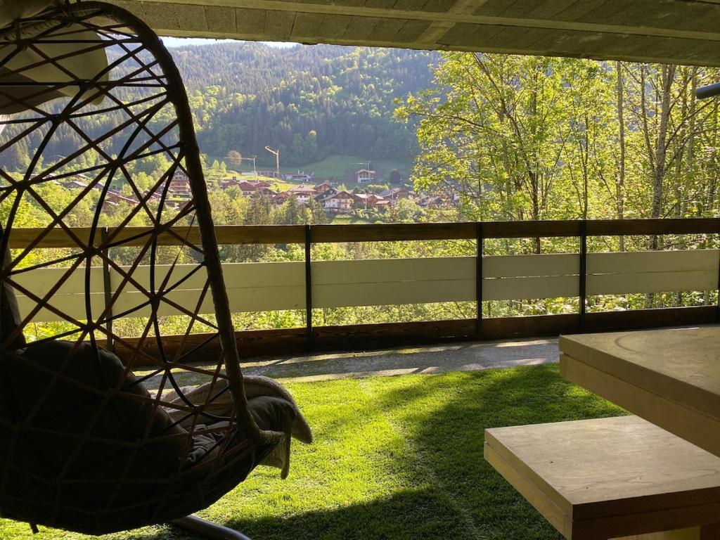 a rocking chair on a balcony with a view at Superbe terrasse proximité centre in Morzine