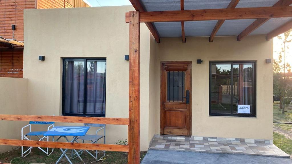 a small house with a porch and a table and chairs at Rojavitiva in General Belgrano