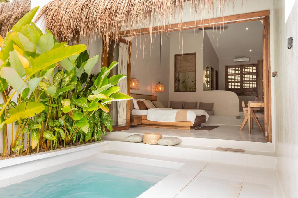 ein Schlafzimmer mit Pool und einem Bett in einem Zimmer in der Unterkunft Suenos Villas Siargao in General Luna