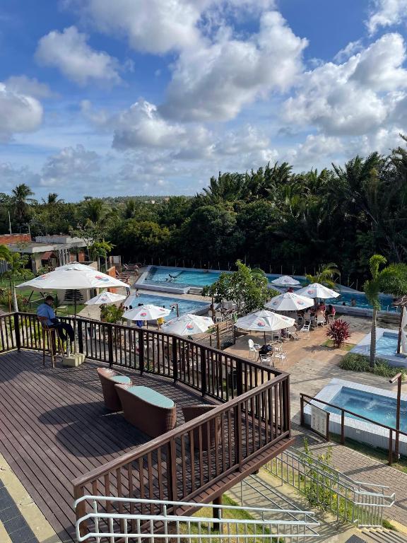 a view of a resort with two pools and umbrellas at CAMINHOS do MAR ACOMODAÇÕES in Parnamirim