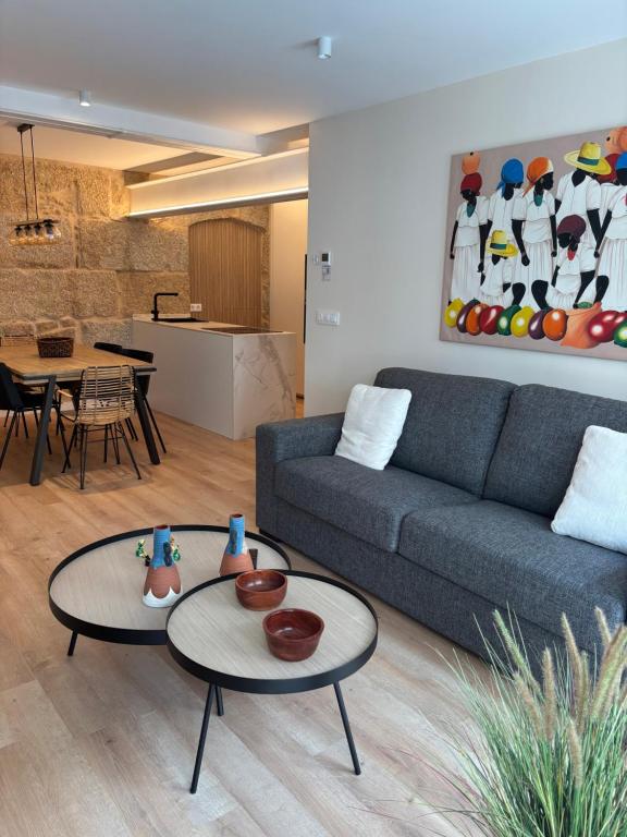 een woonkamer met een bank en twee tafels bij LAS TERRAZAS I in Ourense