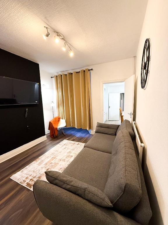 a living room with a couch and a flat screen tv at Spacious 3 Bed , Free Parking , Fast WiFi , Long Stays in Kettering