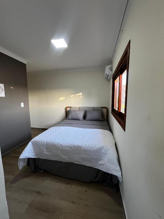 a bedroom with a bed in the corner of a room at quarto stantard 5 in Guarapari