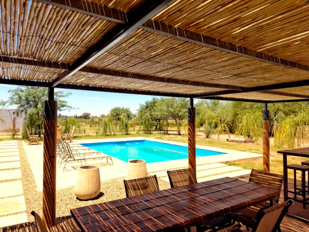 een patio met een houten tafel en een zwembad bij Casa Vergara in Villa Unión