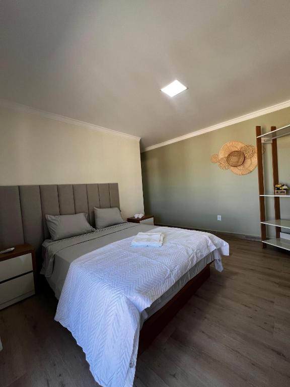 a bedroom with a large bed in a room at Quarto standard 7 pousada village in Guarapari
