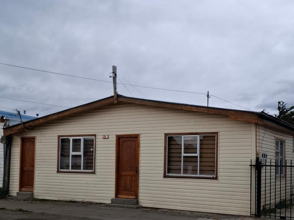 蓬塔阿雷纳斯Ruka Austral的白色的房子,设有窗户和围栏