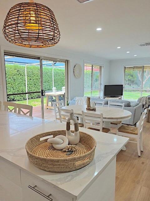 a kitchen and living room with a table and chairs at Coastal Calm in Normanville