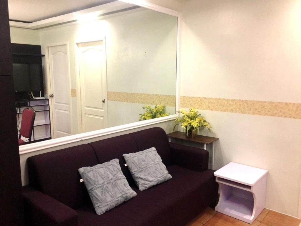 a living room with a couch and a large mirror at Janna's Condo Hotel in Cebu City