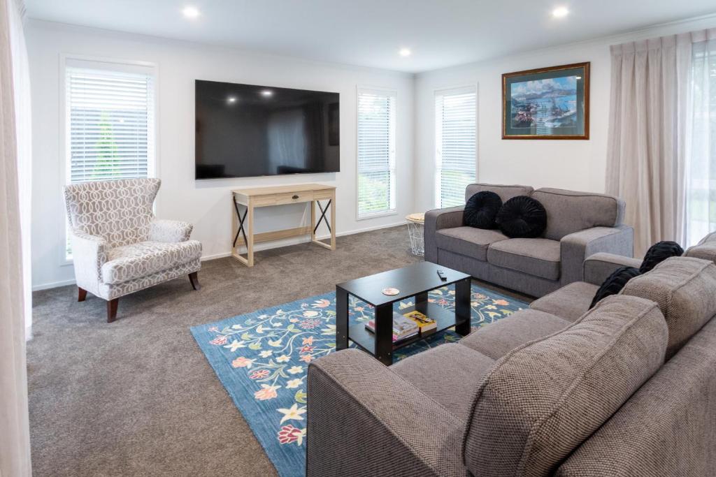a living room with a couch and a tv at Spacious 3BR with 2 carpark in Lincoln