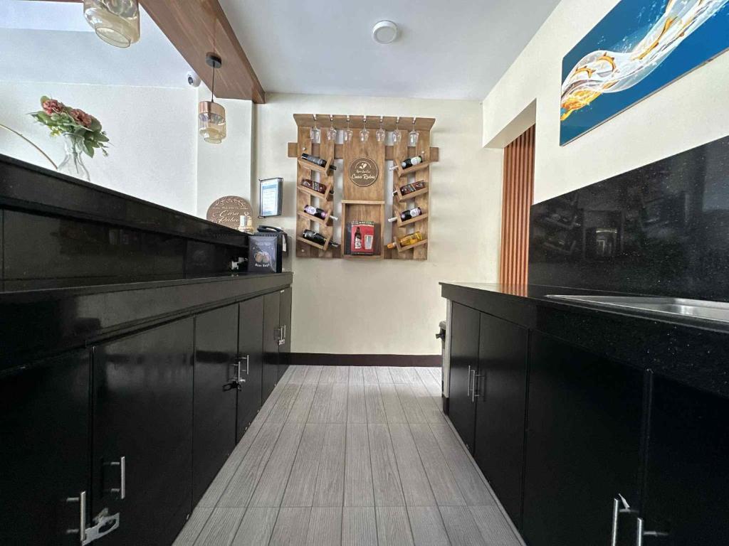 a large kitchen with black cabinets and a sink at Casa Rubio private Resort in Los Baños
