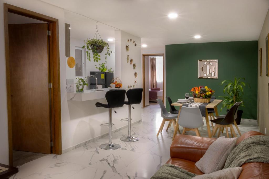 a living room with a couch and a table with chairs at Santuario De Luna, Departamento in Cholula