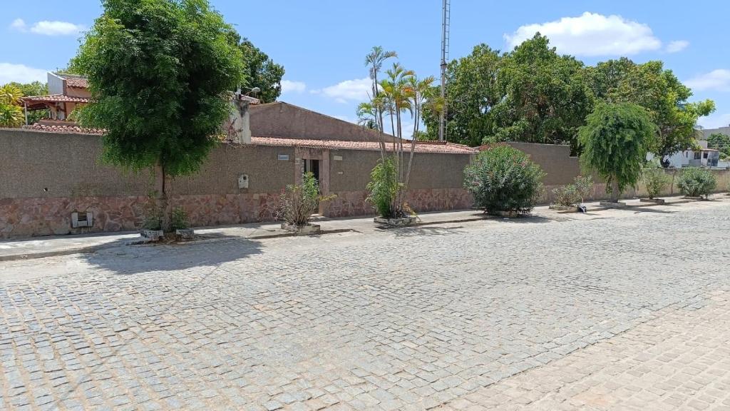 a brick courtyard with trees in front of a building at Recanto Sossego I in Tucano