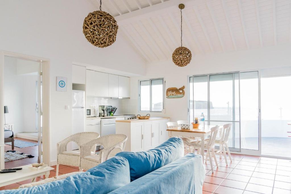 a living room with a couch and a kitchen at Quo Mosteiros Sunset House in Mosteiros