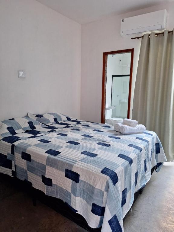 a blue and white bed in a room with a window at Suíte Recanto dos poetas 06 in Lençóis