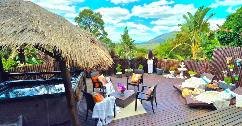 a deck with a pool and chairs and a umbrella at Mountain View Spa Cottage in The Basin