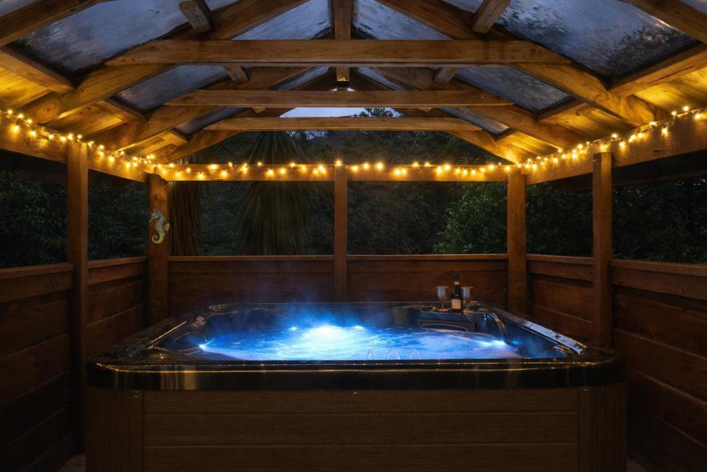 a jacuzzi tub with lights on top of it at Hill Top Hideaway - Self Contained Guest Suite with Private Spa in Pukerua Bay