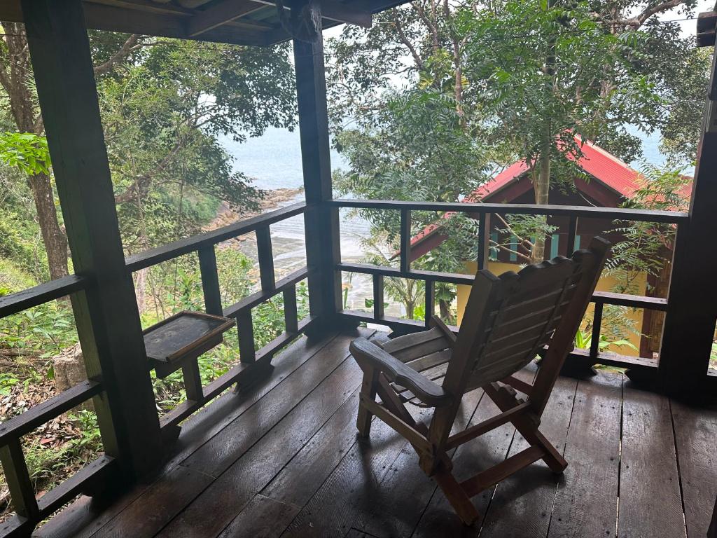 una sedia a dondolo su un portico che guarda l'oceano di Mama's Bungalows Koh Chang Ranong a Ko Chang (Ranong)