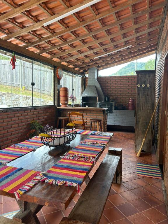 a patio with a table and benches and a stove at Casa da Cuca in Nova Friburgo