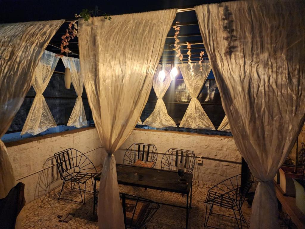 a room with a table and chairs and curtains at Hathai in Jodhpur