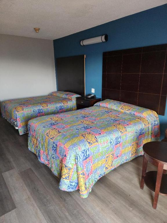 two beds sitting next to each other in a room at WESTERN MOTEl in Lucedale