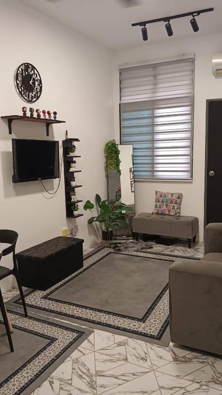 a living room with a couch and a tv at MiniHaus2Stay in Pulau Sebang