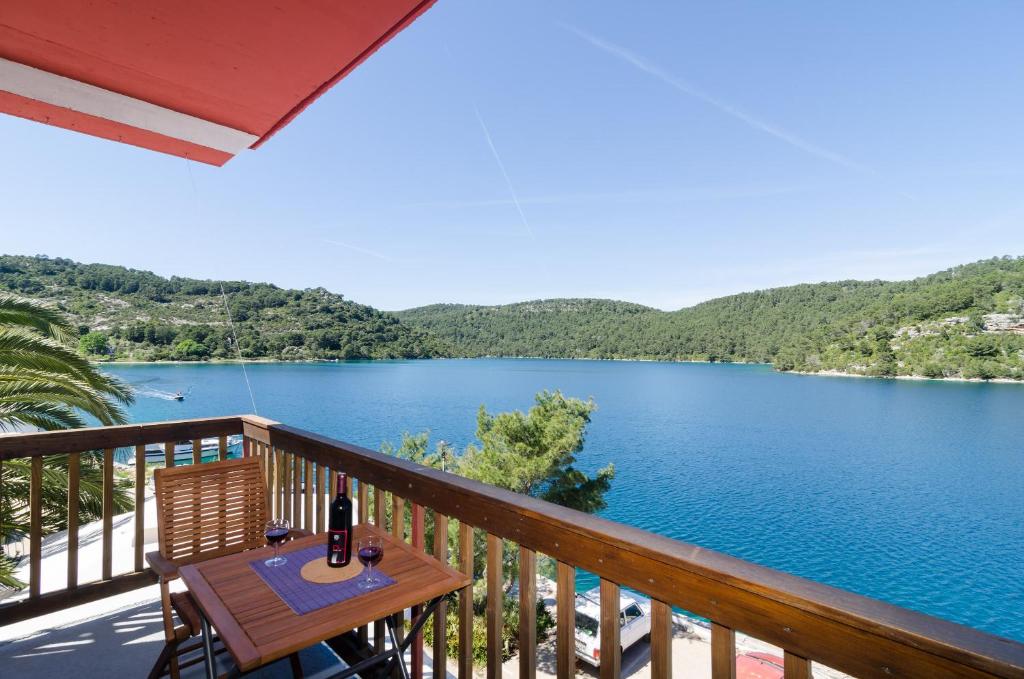 uma varanda com uma mesa e vista para um lago em Apartments Matana Chano em Polače