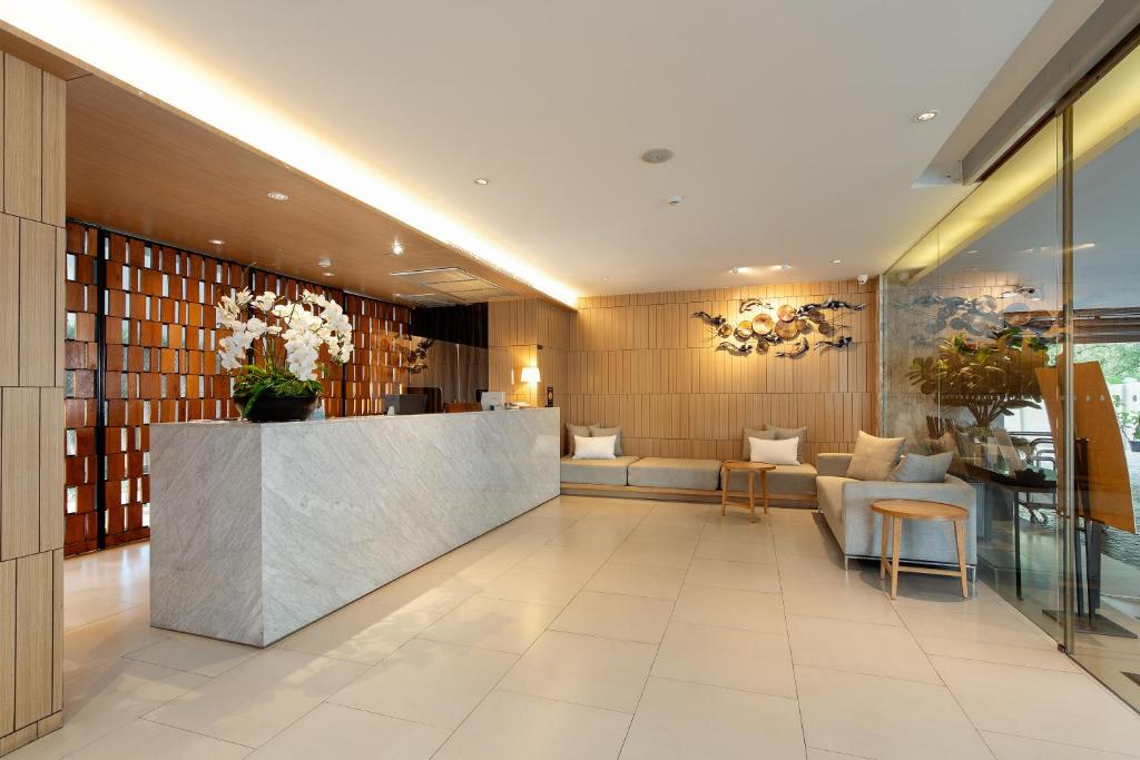 A reception lobby with lounge seating beside a glass-fronted wall.