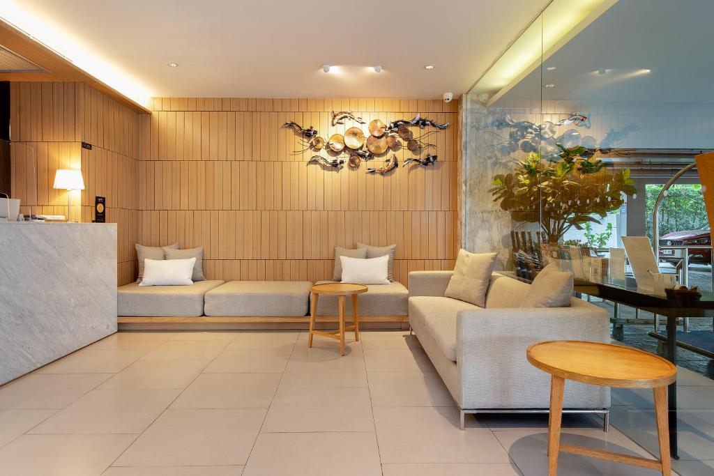 A lobby seating area with sofas, small tables, and a glass wall beside the entrance.
