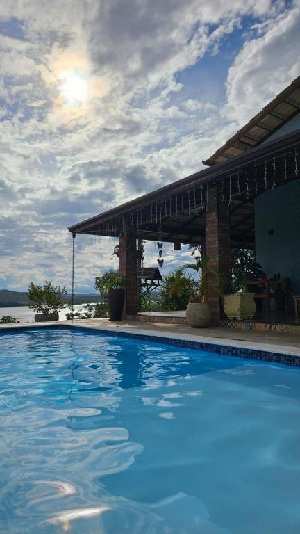 a large blue swimming pool in front of a house at Rancho dos Ipês Corumbá in Alexânia