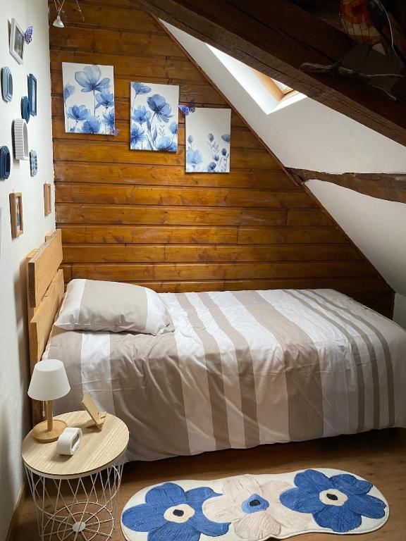 a bedroom with a bed and a wooden wall at Au Pied de Troncais in Coust