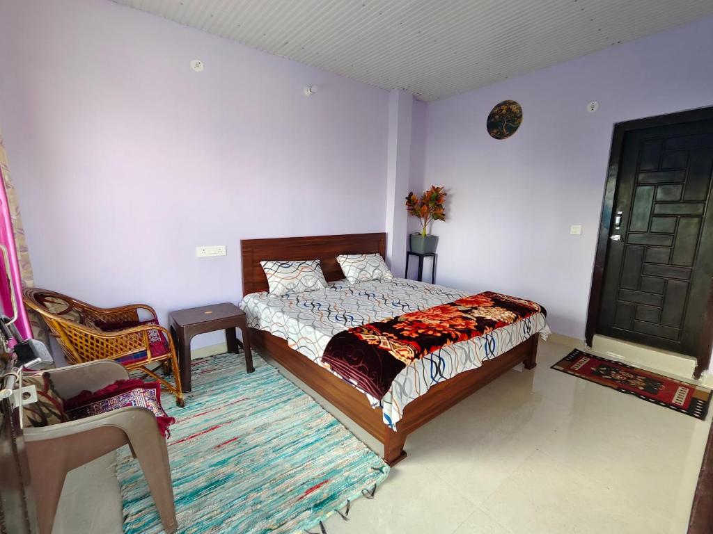 a bedroom with a bed and a chair and a door at Bilju Homestay in Munsyari