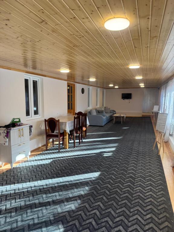 een kamer met een tafel, stoelen en een bank bij House 39 in Sheki