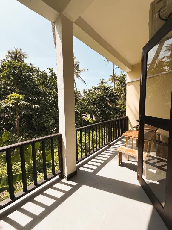 a balcony with a bench and a view of trees at Nirvana Surf Retreat - Kabalana in Atadahewatugoda