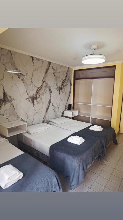 a hotel room with two beds with towels on them at Piso entero La Boca in Buenos Aires