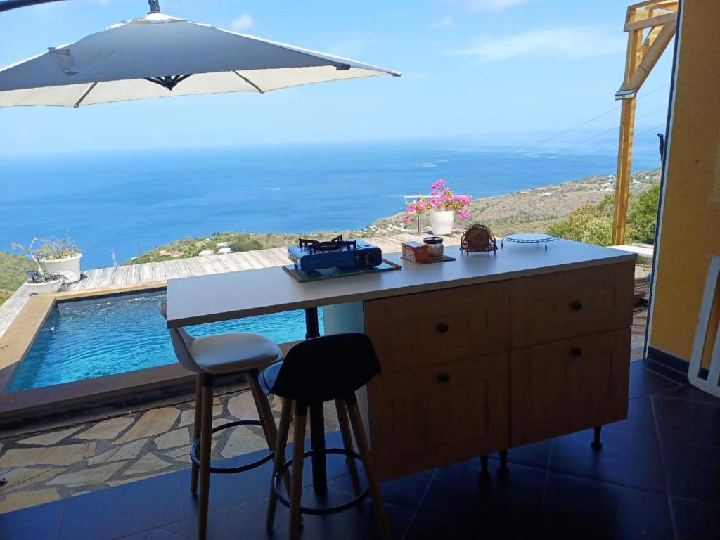 a kitchen with a table and a view of a pool at Kevio in Chambort