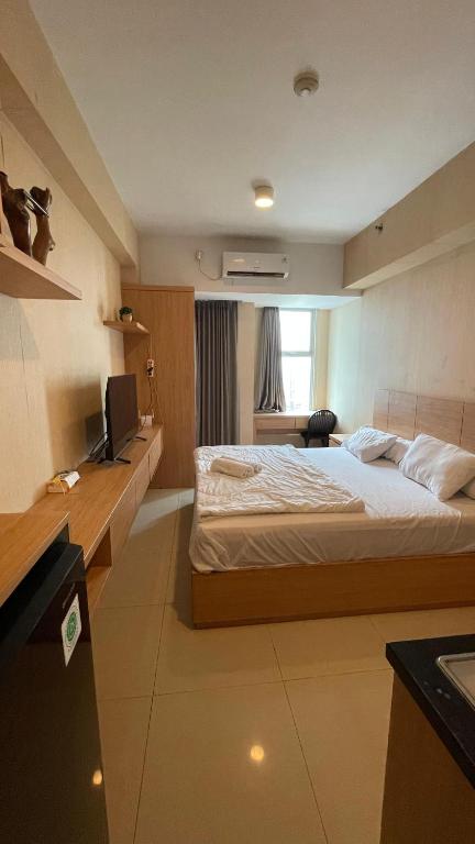 a bedroom with a bed and a desk and a television at ANDERSON BENSON CONNECT PAKUWON MAll in Surabaya