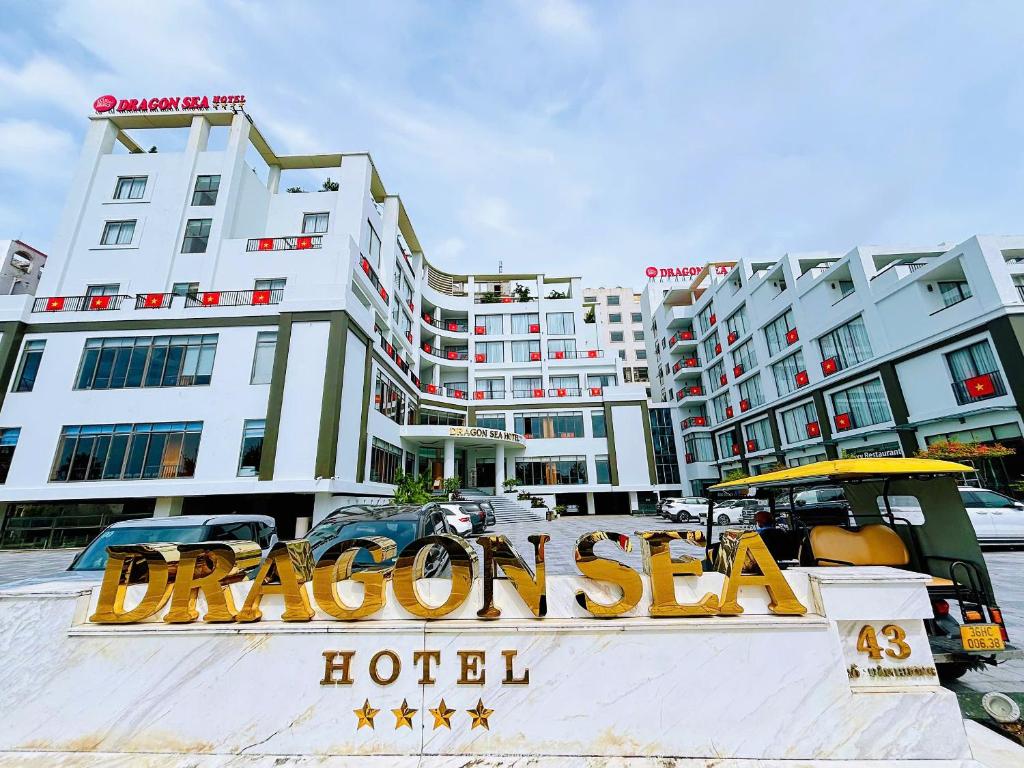 a sign for a hotel in front of some buildings at Dragon Sea Sam Son Hotel in Sầm Sơn