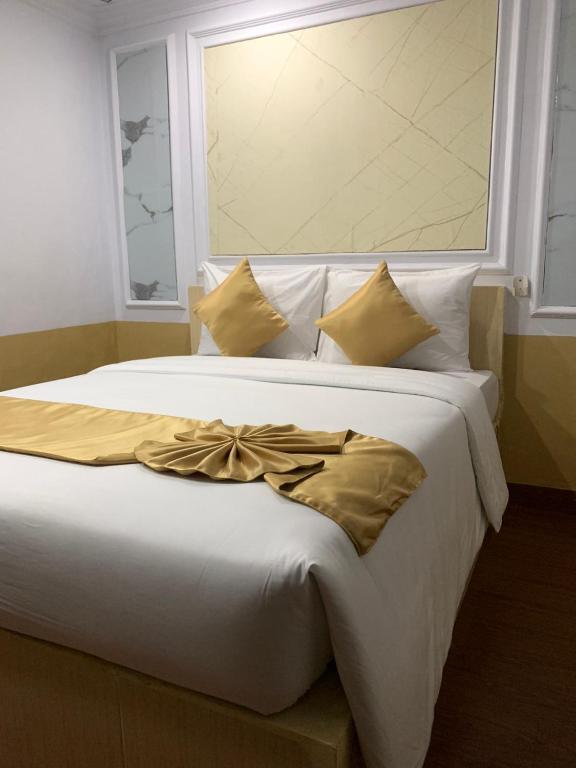 a large white bed with a bow on it at My Home Inn Cibubur in Kranggan-wetan Satu